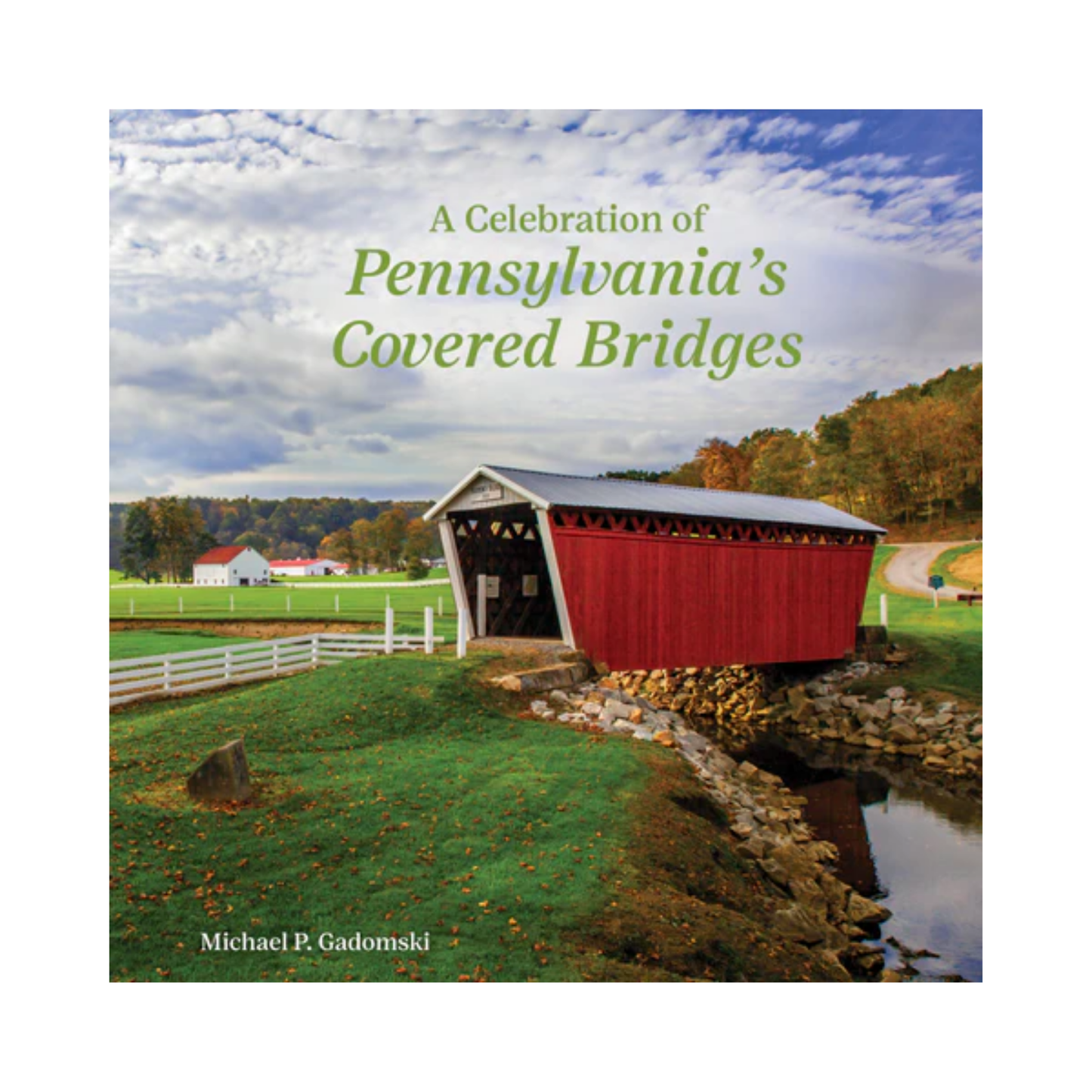 Book cover of 'A Celebration of Pennsylvania's Covered Bridges' with a red covered bridge over a stream.