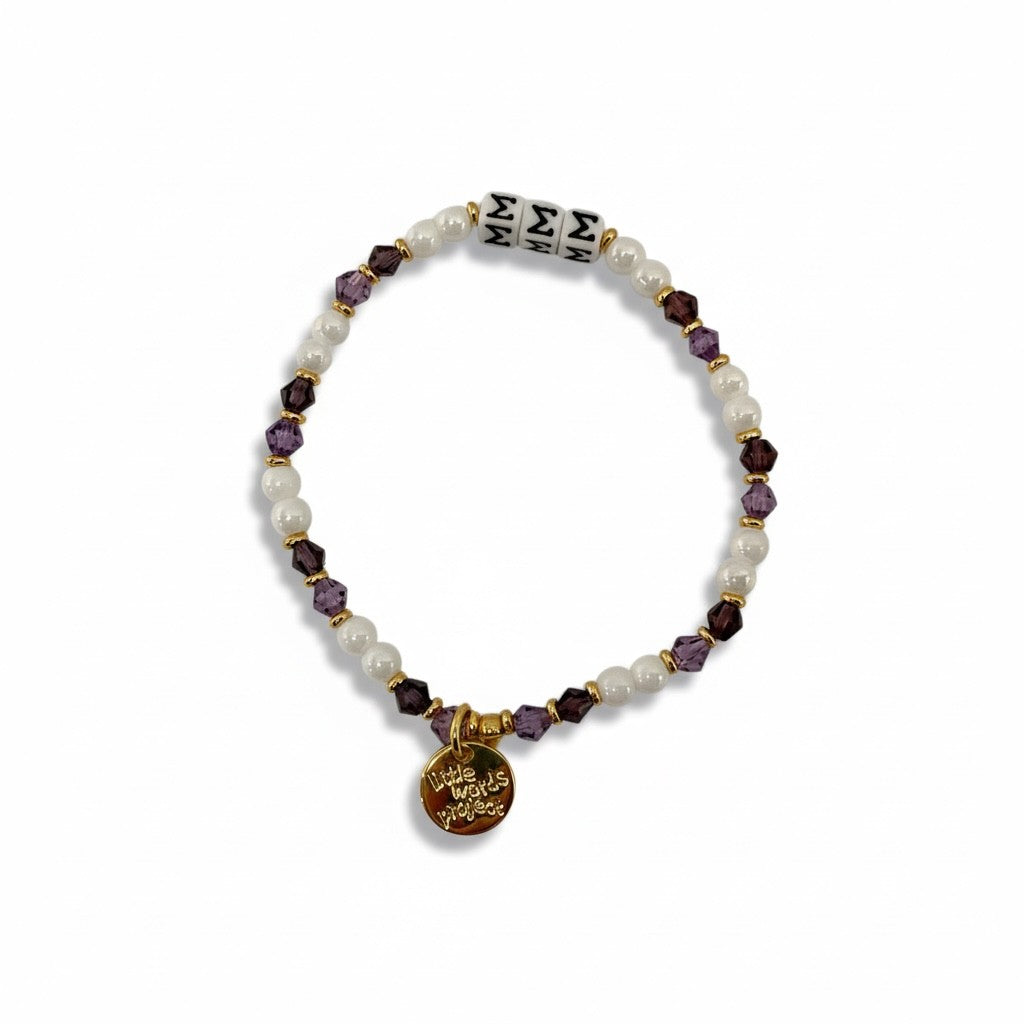 Beaded bracelet with gold charm and purple beads on a white background