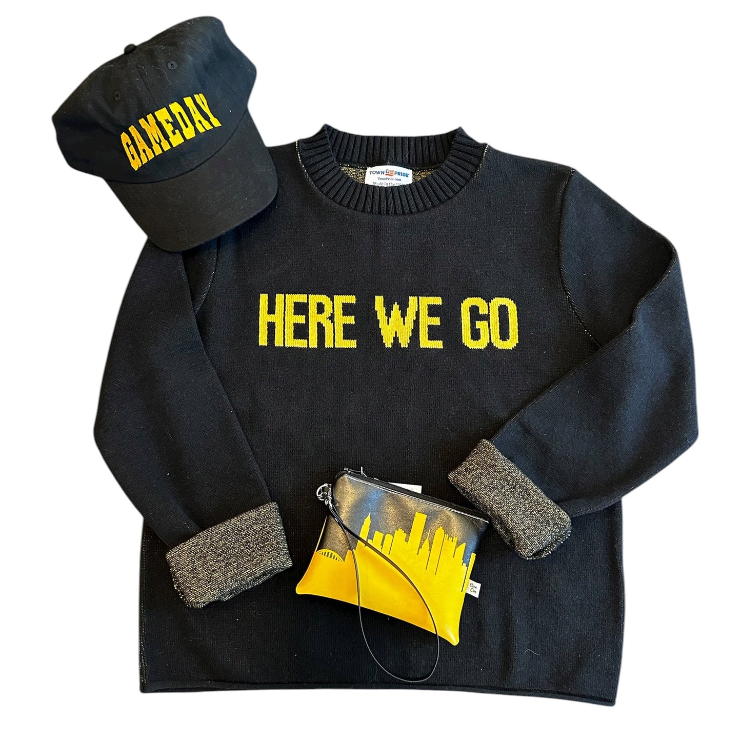 Black sweater with 'HERE WE GO' text, black cap with yellow text, yellow clutch bag on a white background