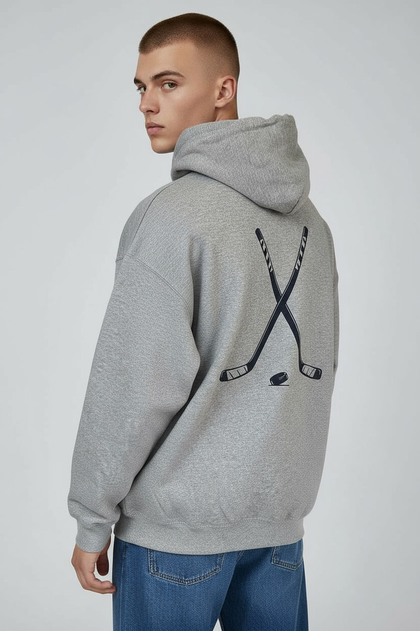 Young man in studio wearing sport grey hockey hoodie with navy back graphic