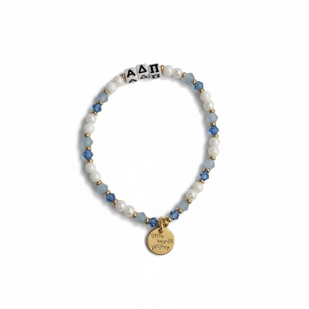 Beaded bracelet with blue and white beads and a gold tag on a white background