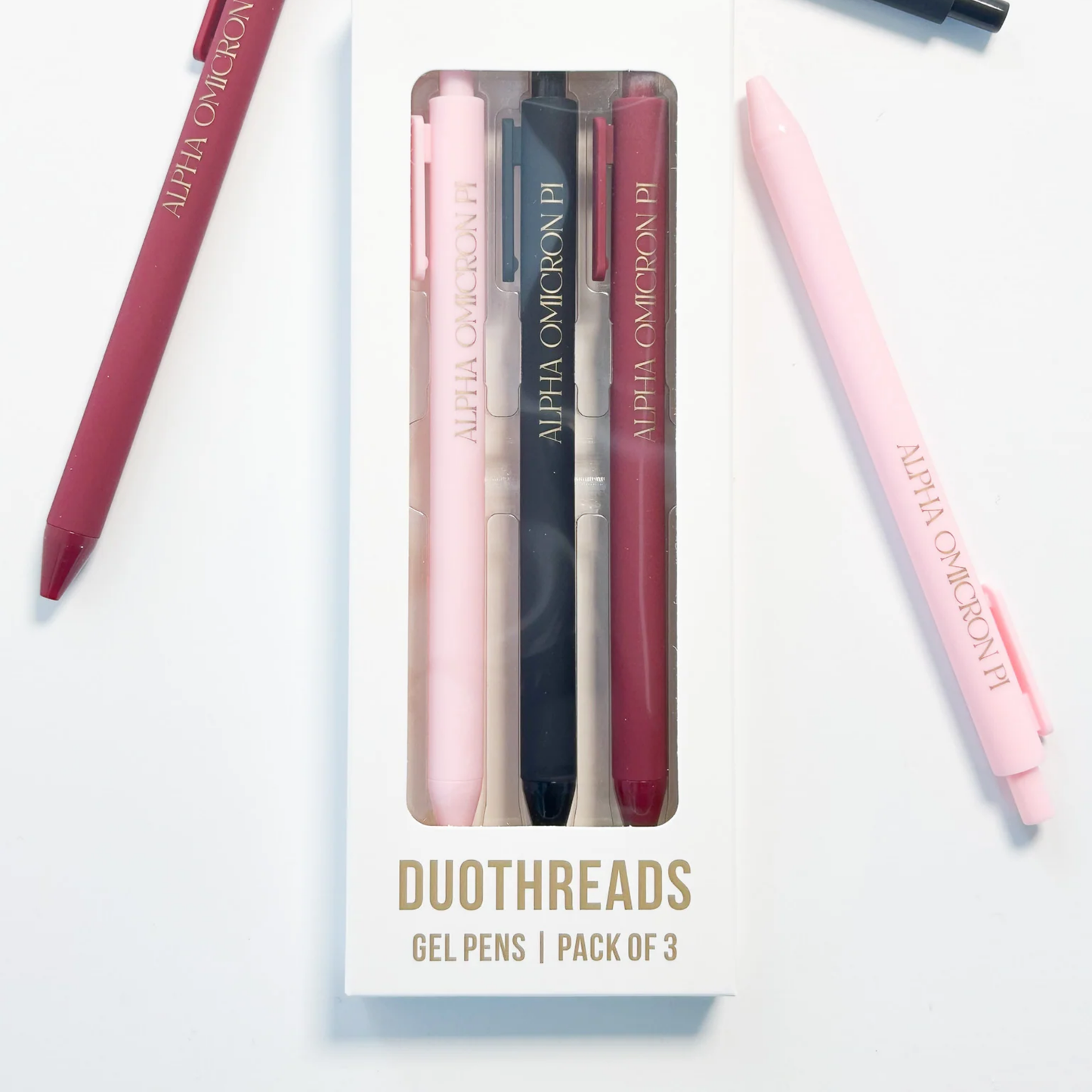 Set of three gel pens in pink, blue, and red with 'Alpha Omicron Pi' branding on a white background.