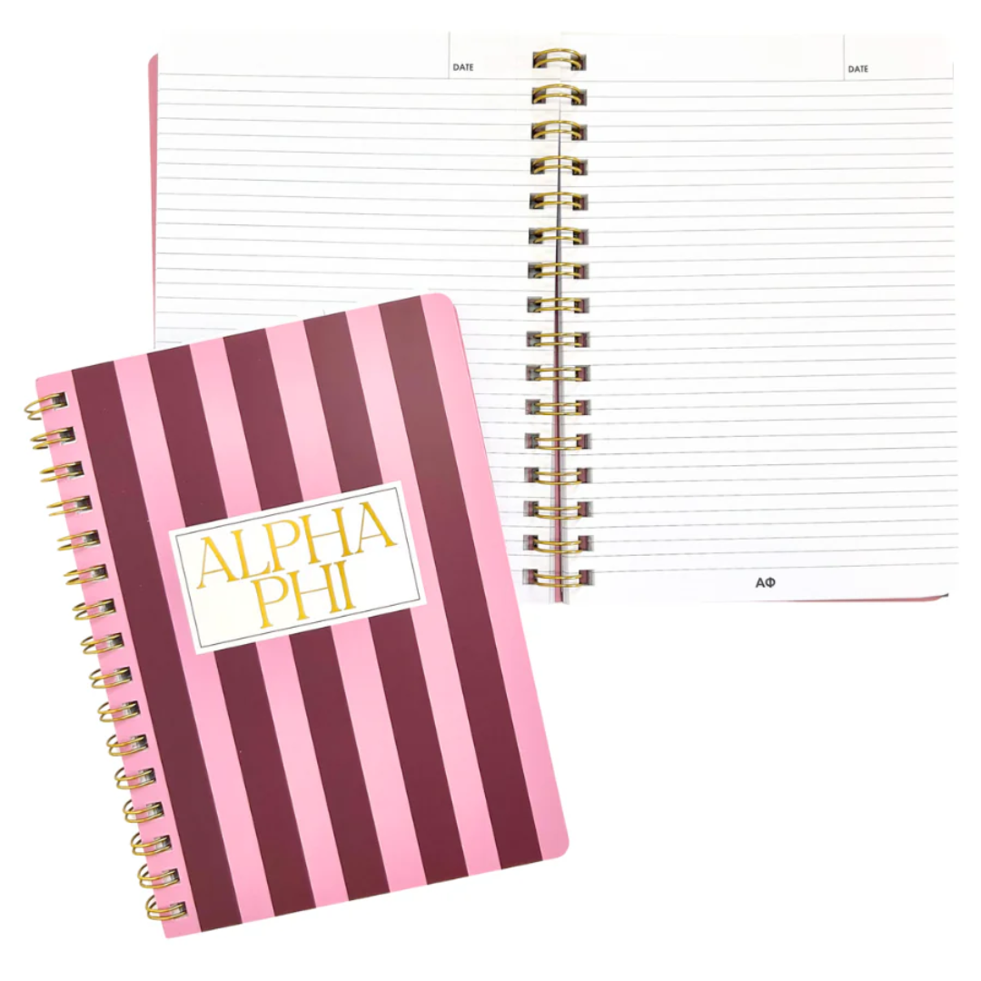 Notebook with pink and purple striped cover and 'Alpha Phi' logo on a white background