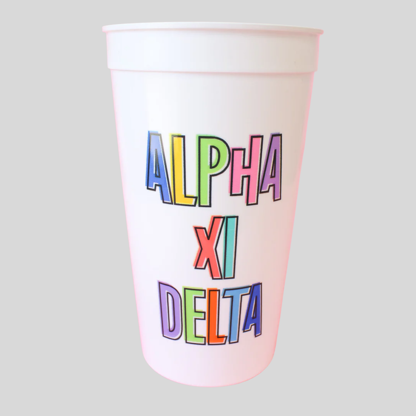 Colorful 'Alpha Xi Delta' text on a white cup against a gray background
