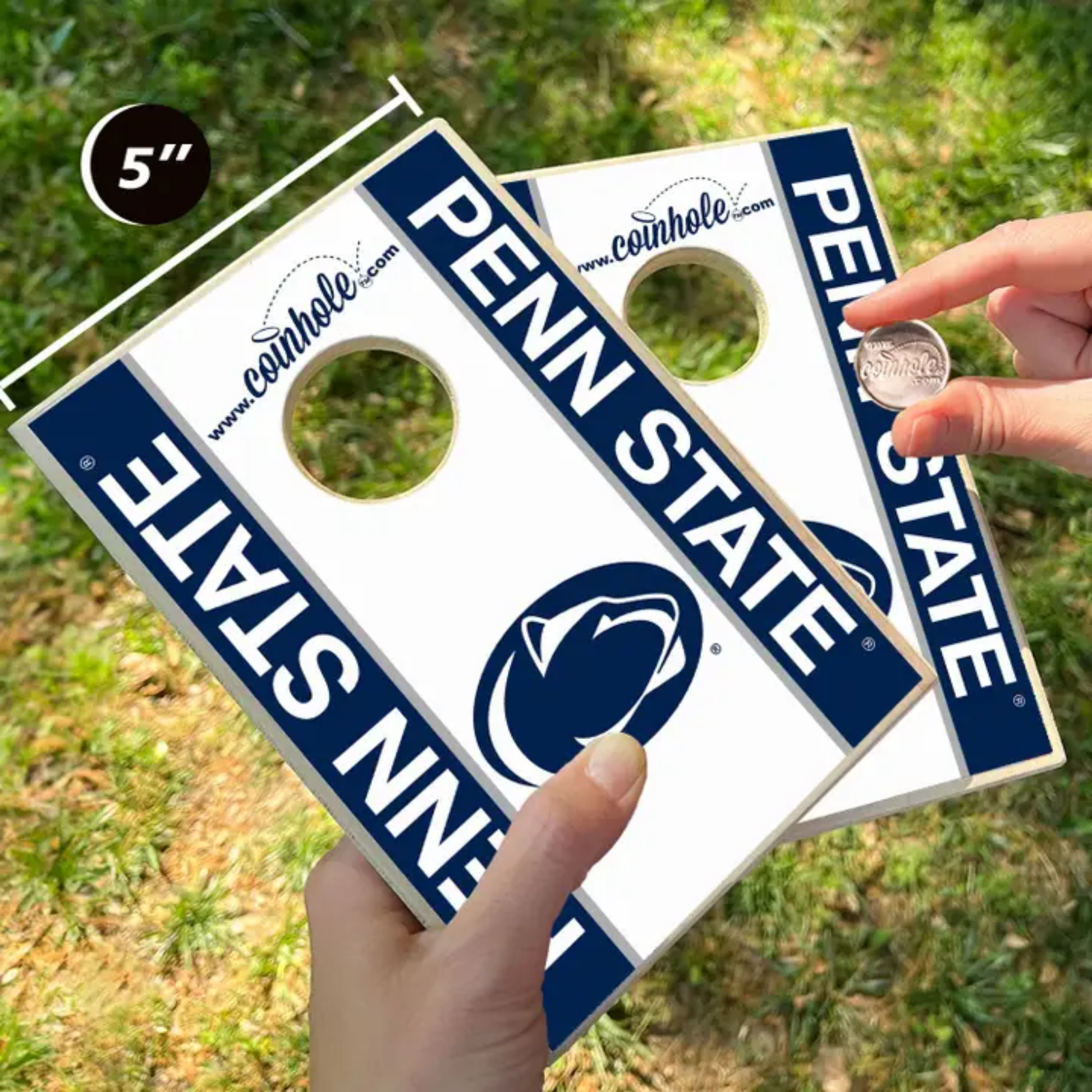 Two Penn State cornhole boards with a coin being used to demonstrate size.