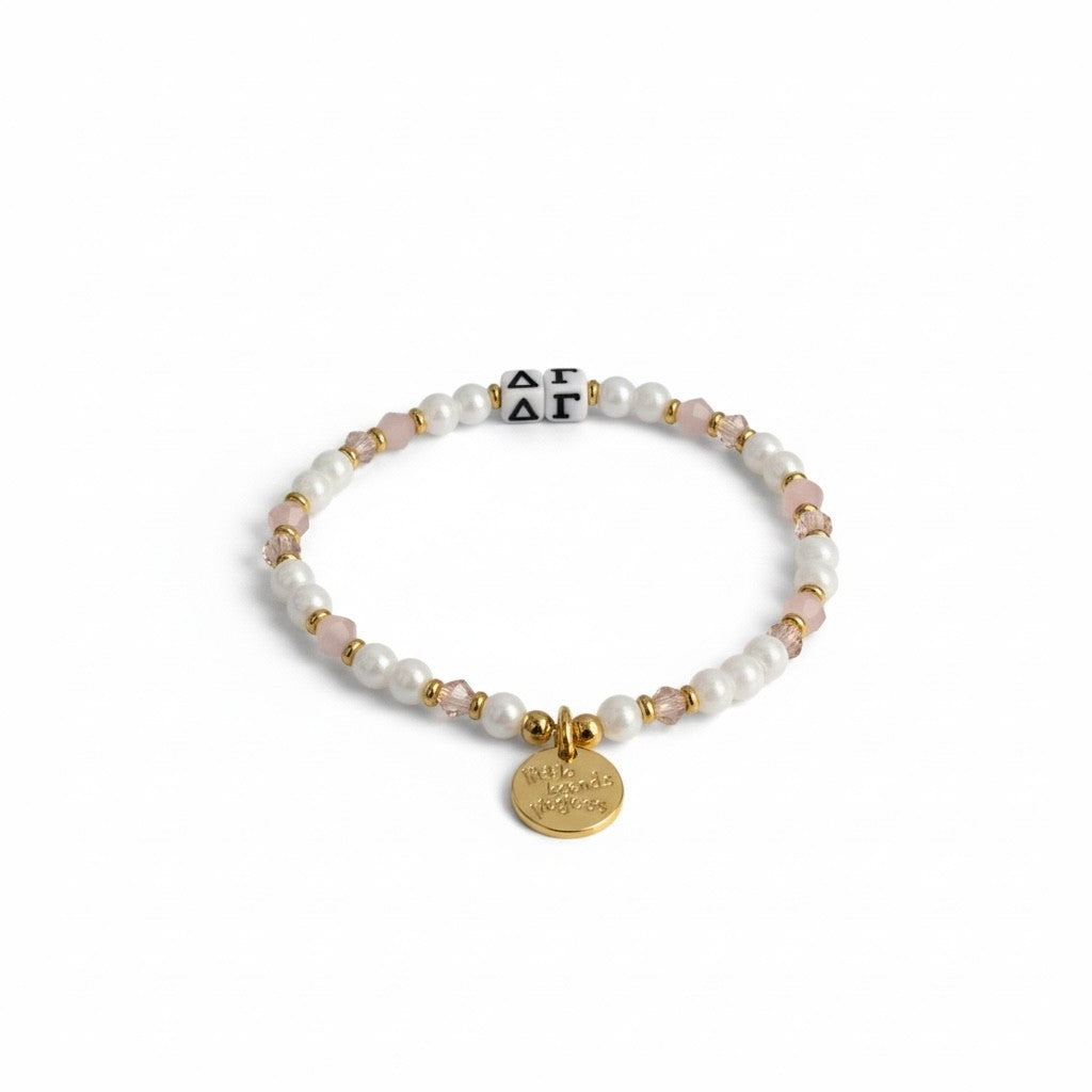 Pearl bracelet with gold accents and a round tag on a white background