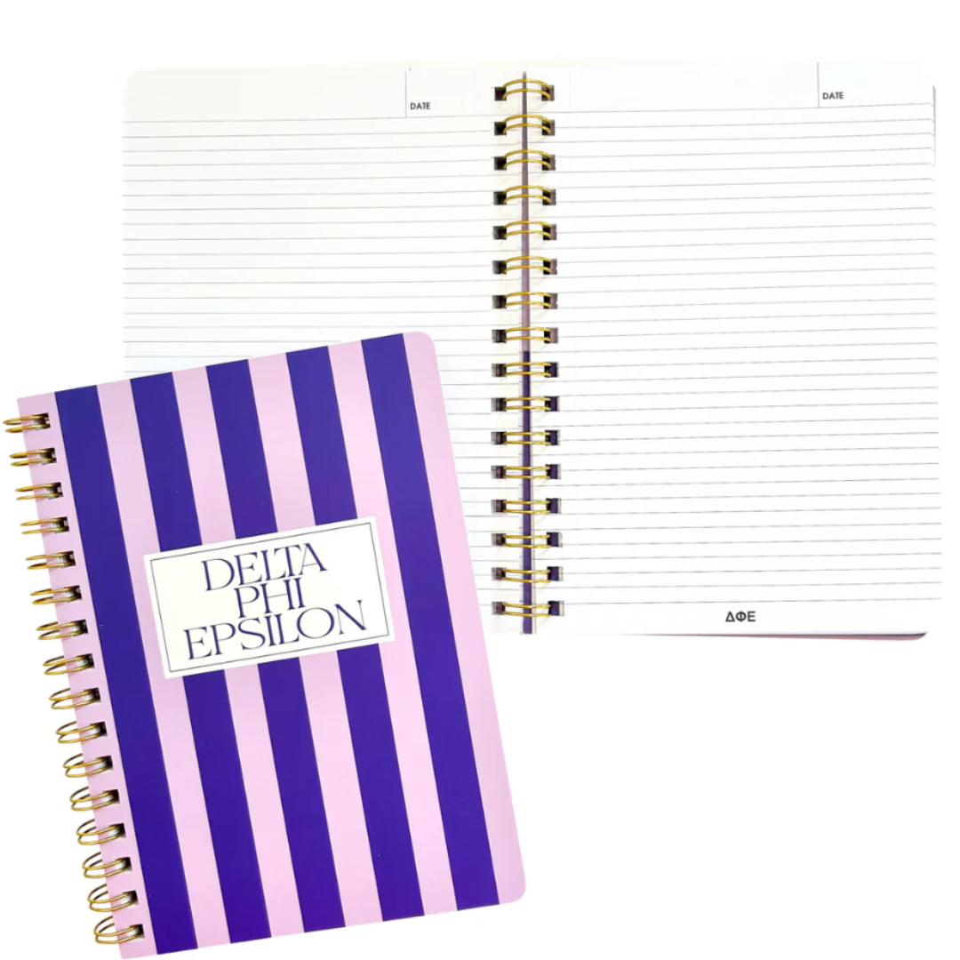 Notebook with purple and white striped cover and 'Delta Phi Epsilon' text on a white background