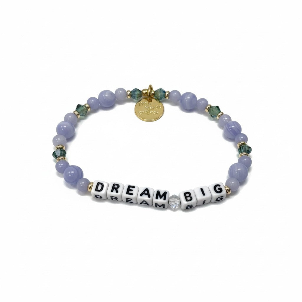Bracelet with purple beads and 'Dream Big' charm on a white background