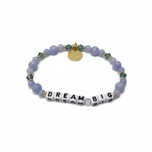 Bracelet with purple beads and 'Dream Big' charm on a white background