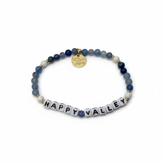 Bracelet with blue beads and 'Happy Valley' tile charm on a white background
