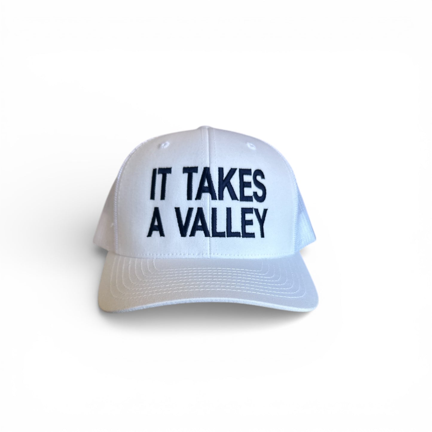 white hat with navy It Takes A Valley on front