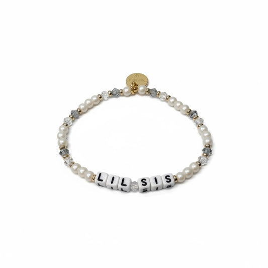 Bracelet with pearls and letter beads spelling 'LIL SIS' on a white background