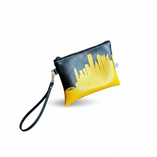 Black wristlet clutch with yellow city skyline design on a white background