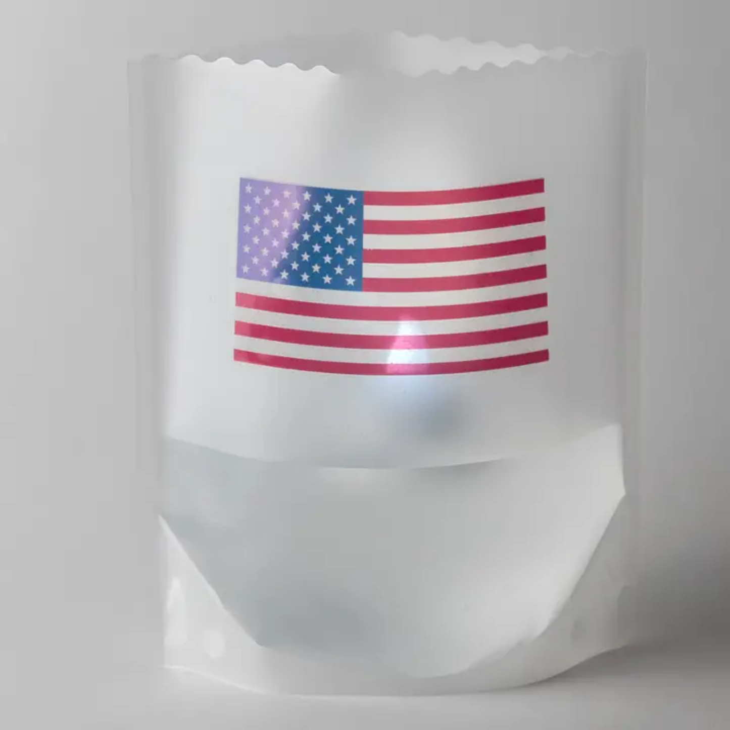 White reusable luminary with an American flag printed on it against a white background