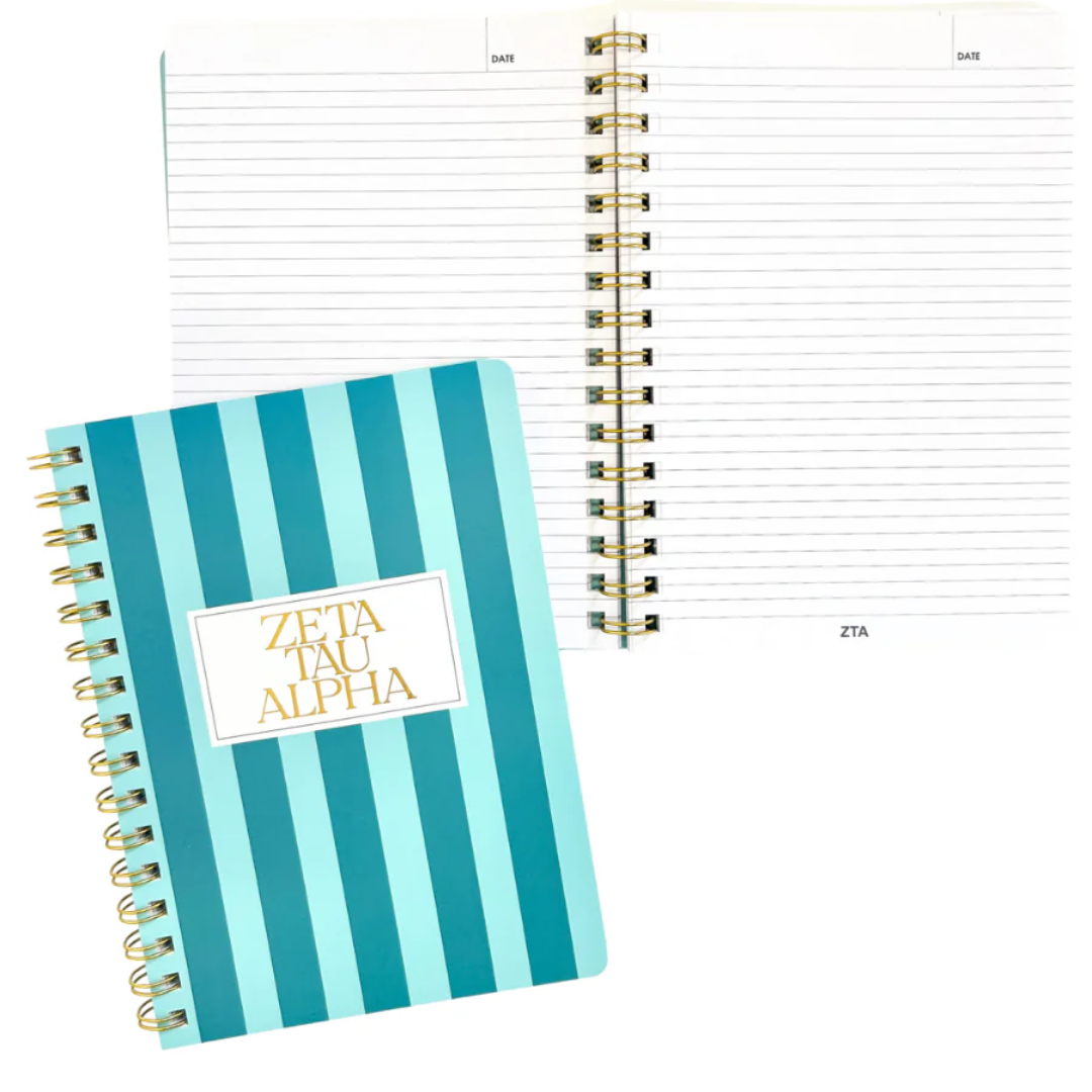 Notebook with blue and white striped cover and 'Zeta Tau Alpha' text on a white background