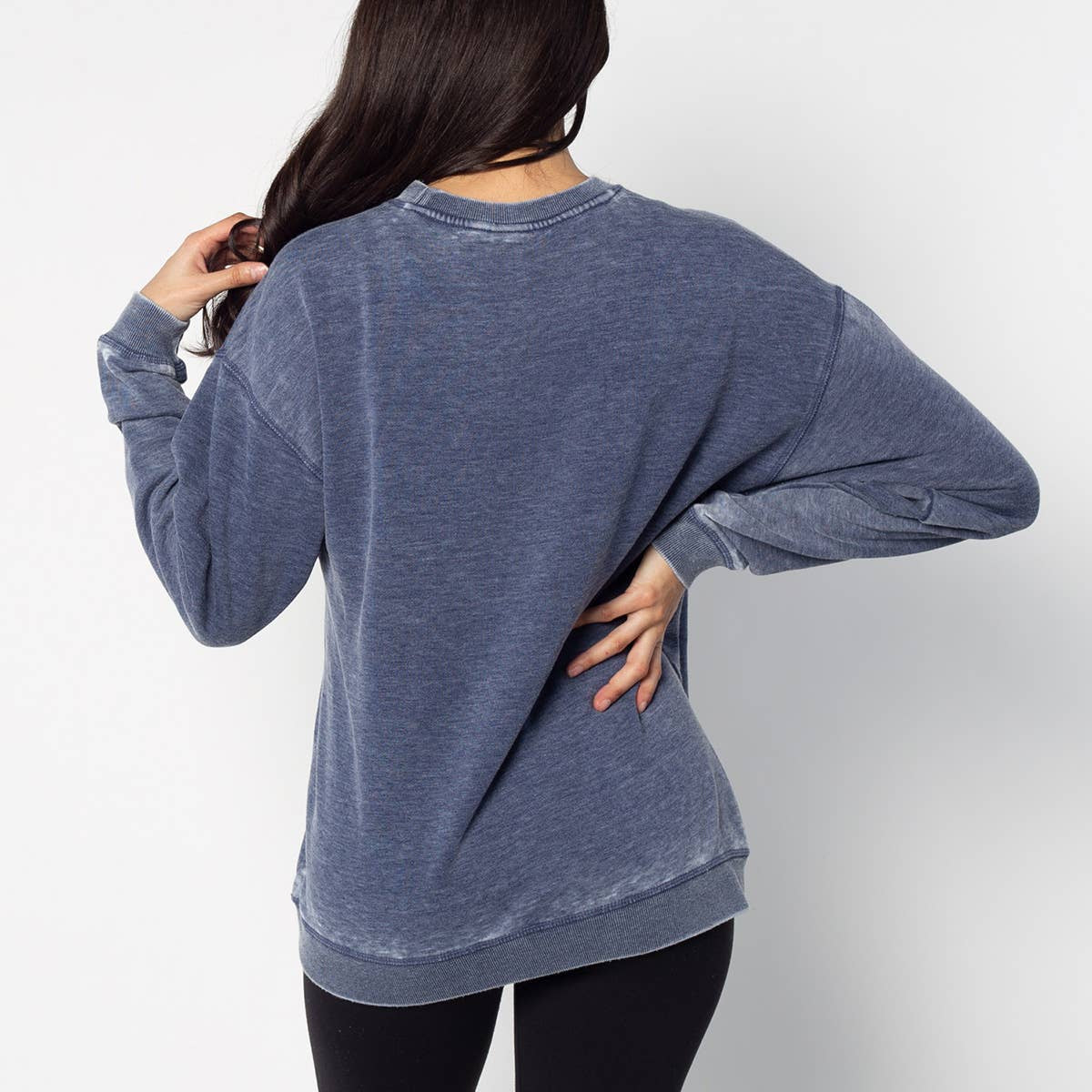 Person wearing a blue oversized sweatshirt on a white background