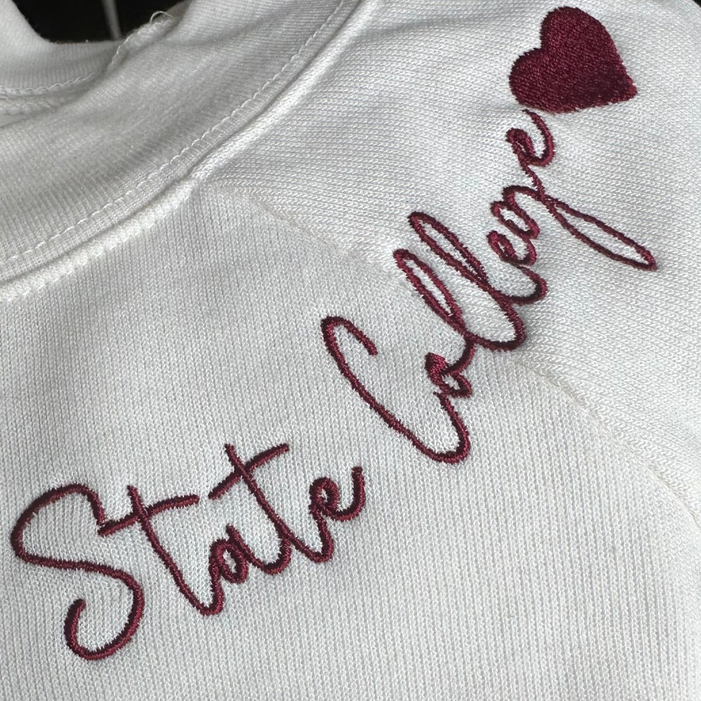 Embroidered text on a garment with a heart symbol