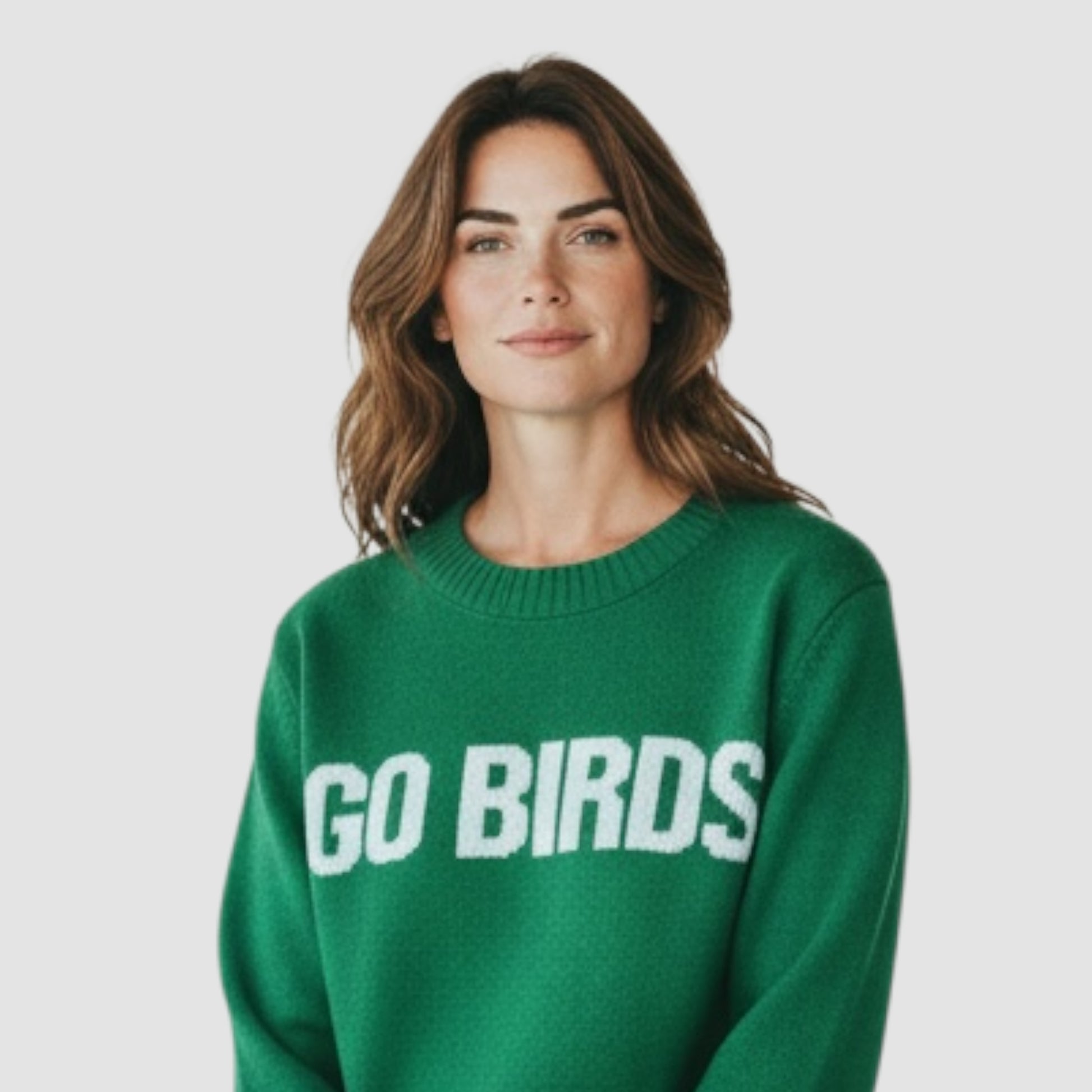 Woman wearing a green sweater with 'GO BIRDS' text on a plain background