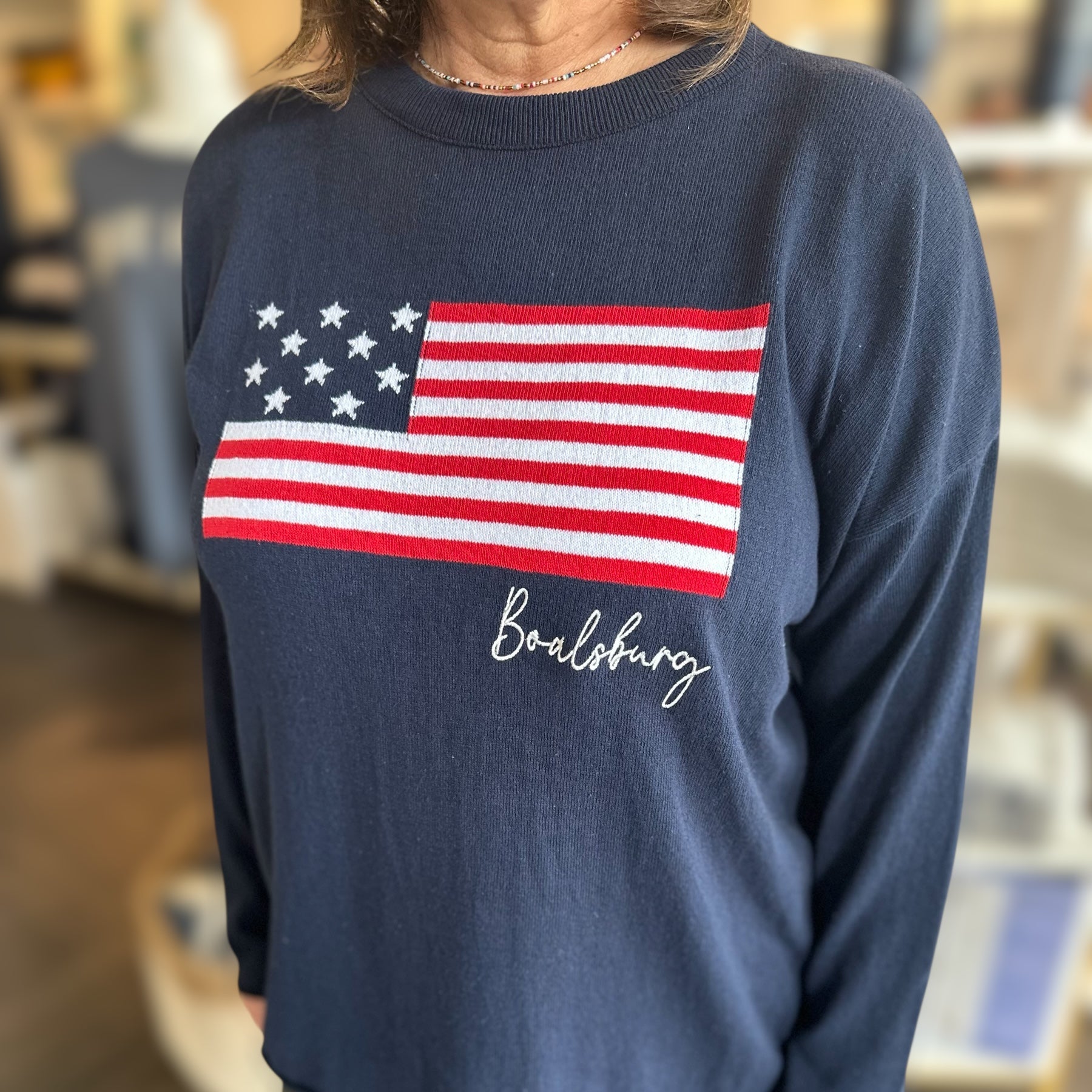 Person wearing a navy blue sweater with an American flag design and 'Boalsburg' text.