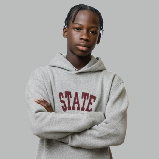 Person wearing a gray hoodie with 'STATE' printed on it against a plain background