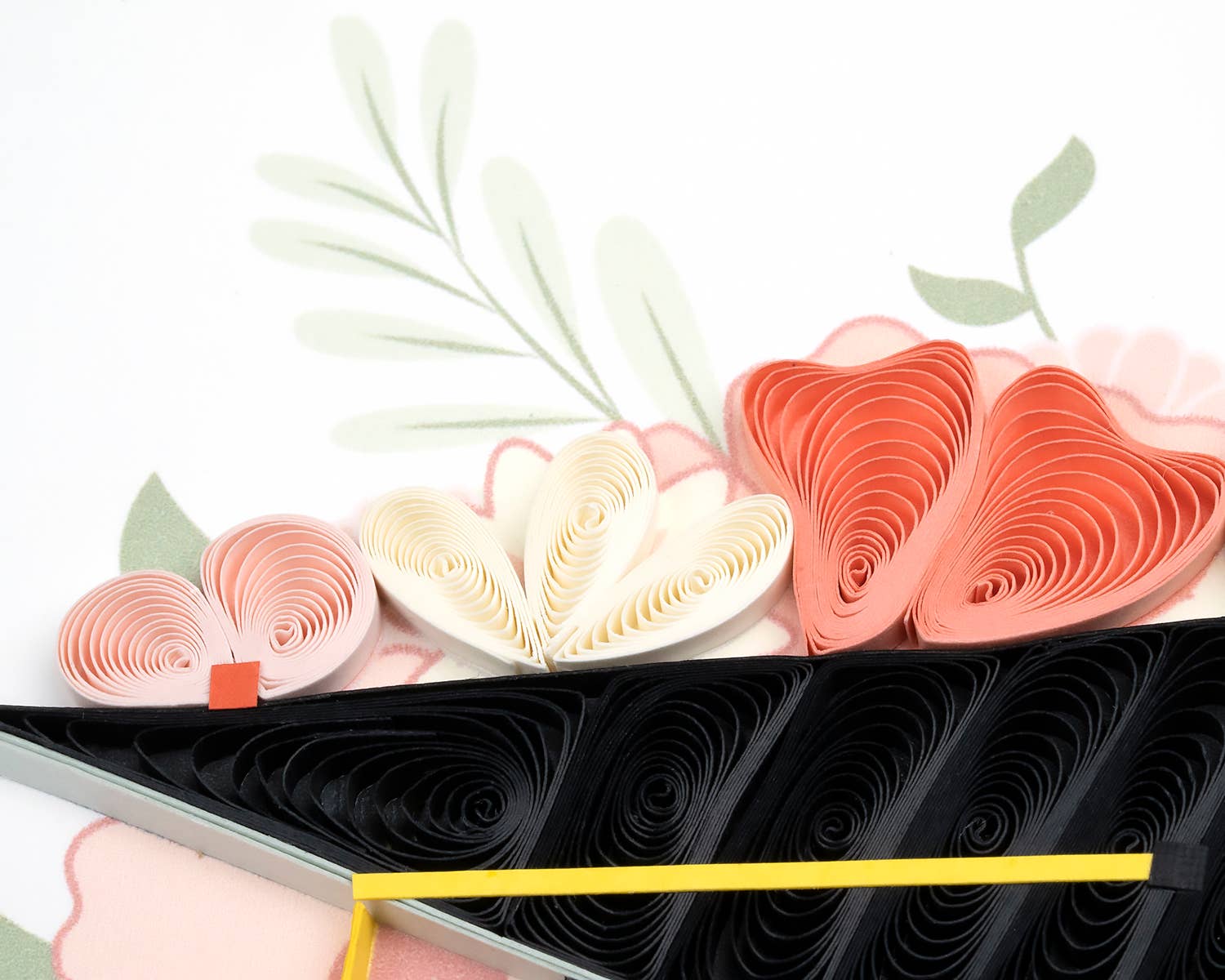 Decorative quilled paper flowers in pink, white, and black on a white background