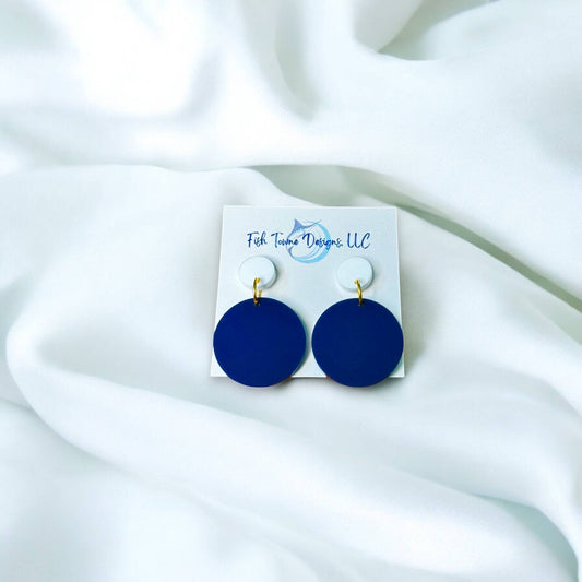 Town Pride State College navy blue circle acrylic earrings with white studs on a display card against white fabric.
