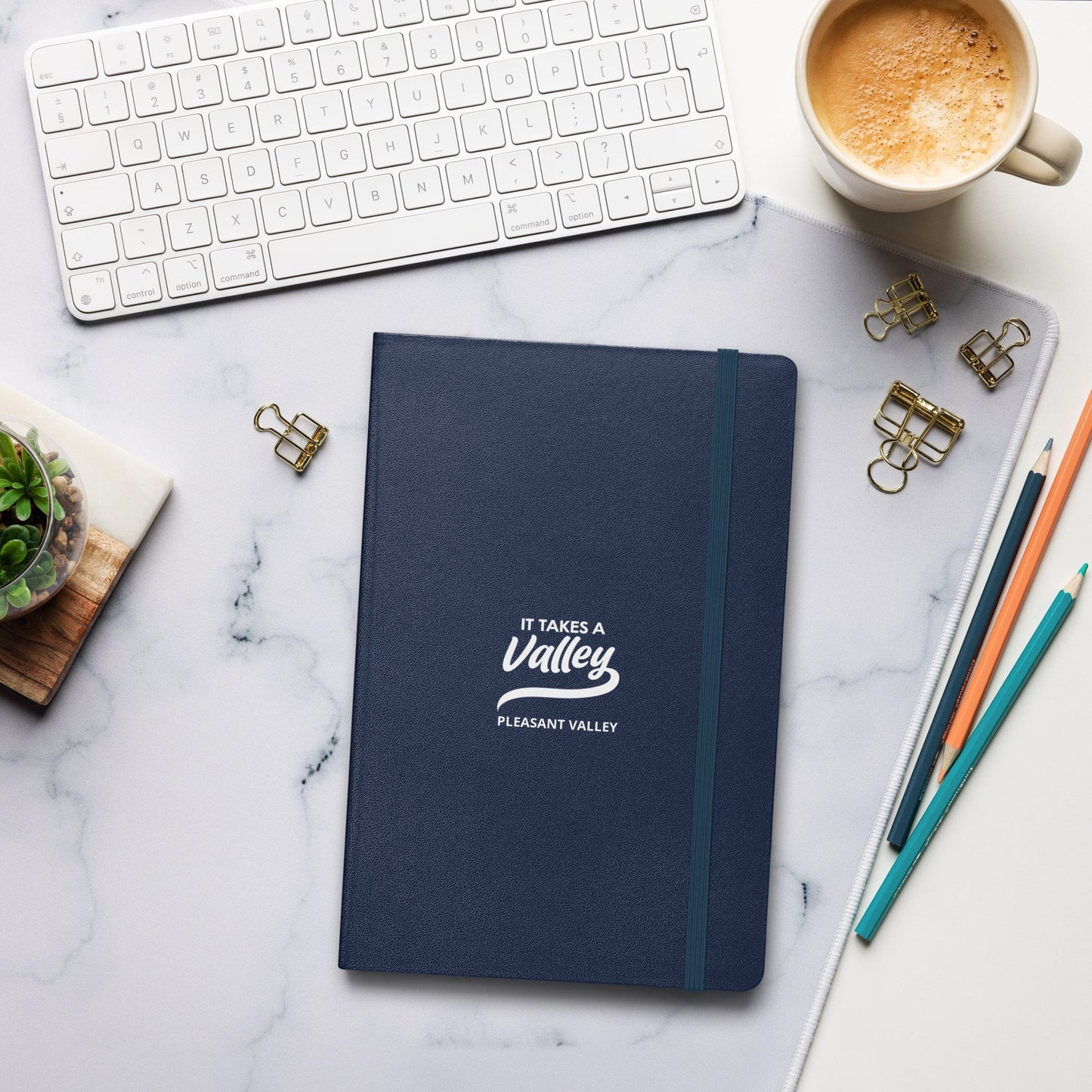 Town Pride State College navy blue hardcover journal with It Takes a Valley Pleasant Valley branding on a desk.