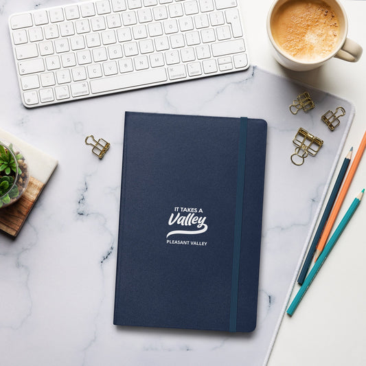 Town Pride State College navy blue hardcover journal with It Takes a Valley Pleasant Valley branding on a desk.
