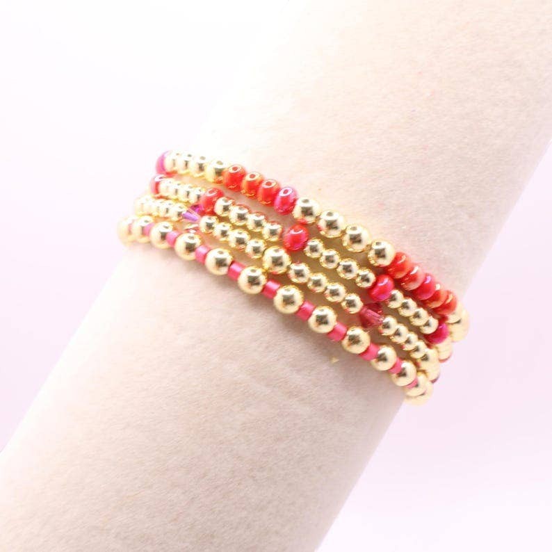 Town Pride State College hot pink and gold hematite stretch bracelet stack worn on a wrist
