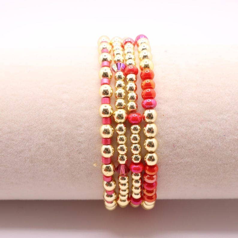 Town Pride State College hot pink and gold hematite stretch bracelet stack of five beaded bangles on a display stand.