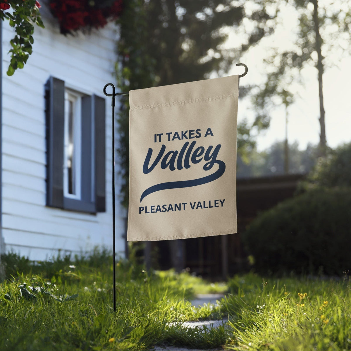 Town Pride State College It Takes A Valley Pleasant Valley garden flag in beige polyester displayed in a front yard.
